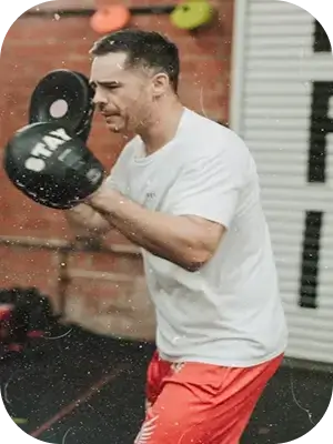 Тренер держит боксёрские лапы для отработки ударов